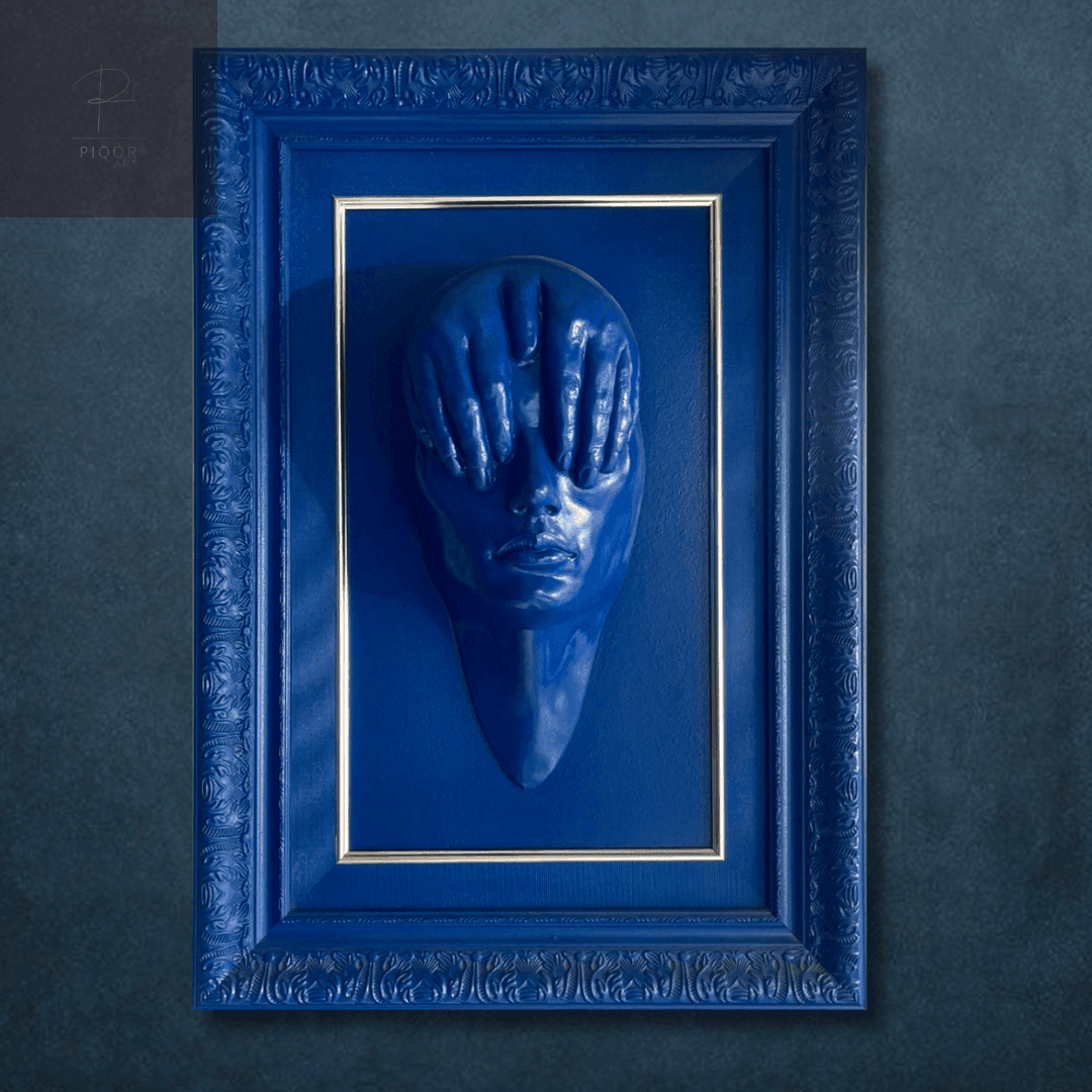 Blue ornate frame hanging on a textured wall with an abstract shape inside.